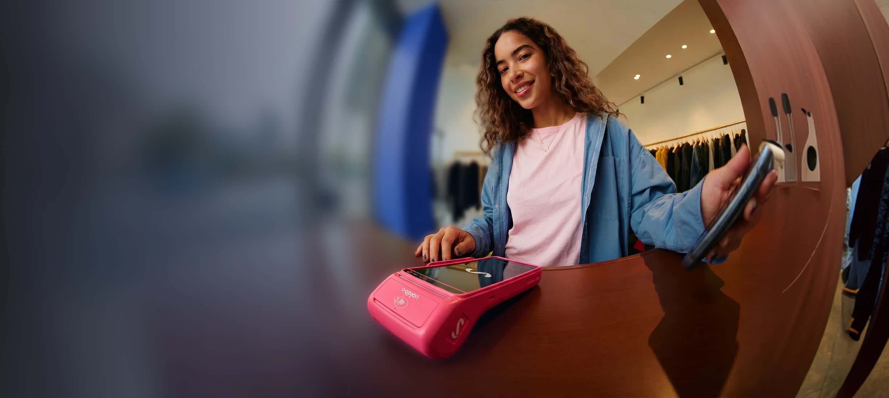 Imágen de una chica cobrando en su negocio